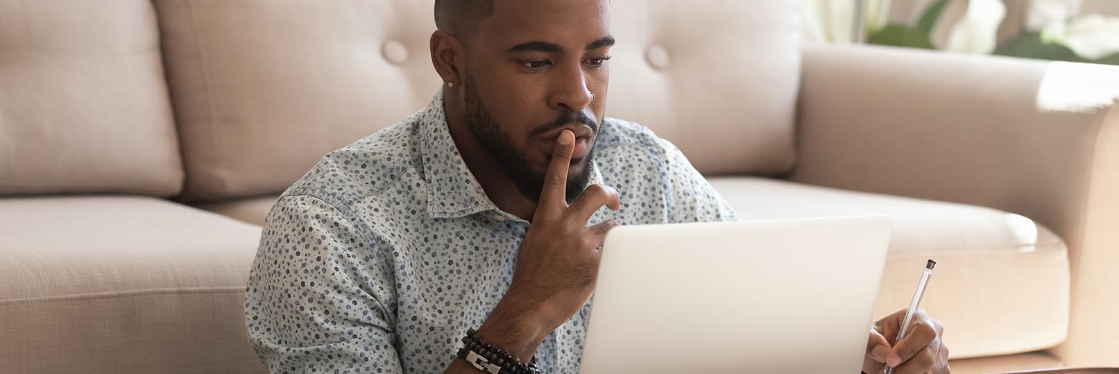 man sitting in front of a laptop computer at home